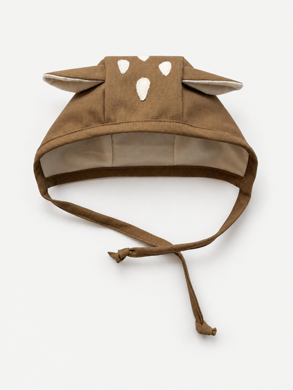 A brown fabric baby fawn bonnet with long ear, and adjustable tie straps, shown on a plain light background.