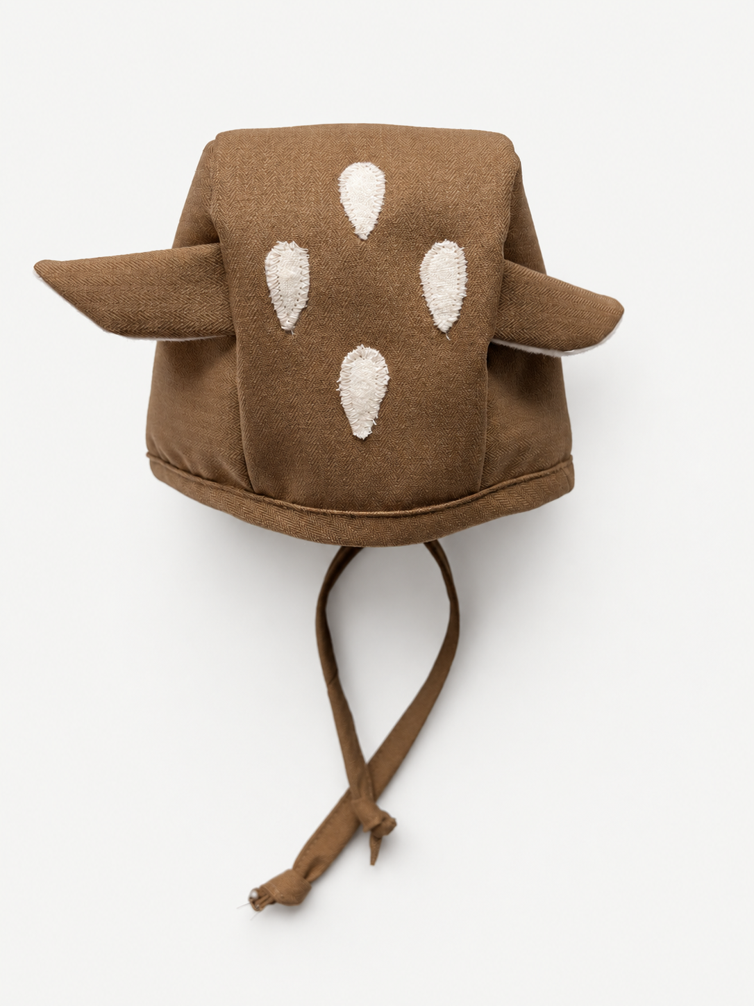 A brown fabric animal-style hat with pointed ears and white embroidered spots, shown against a plain white background.