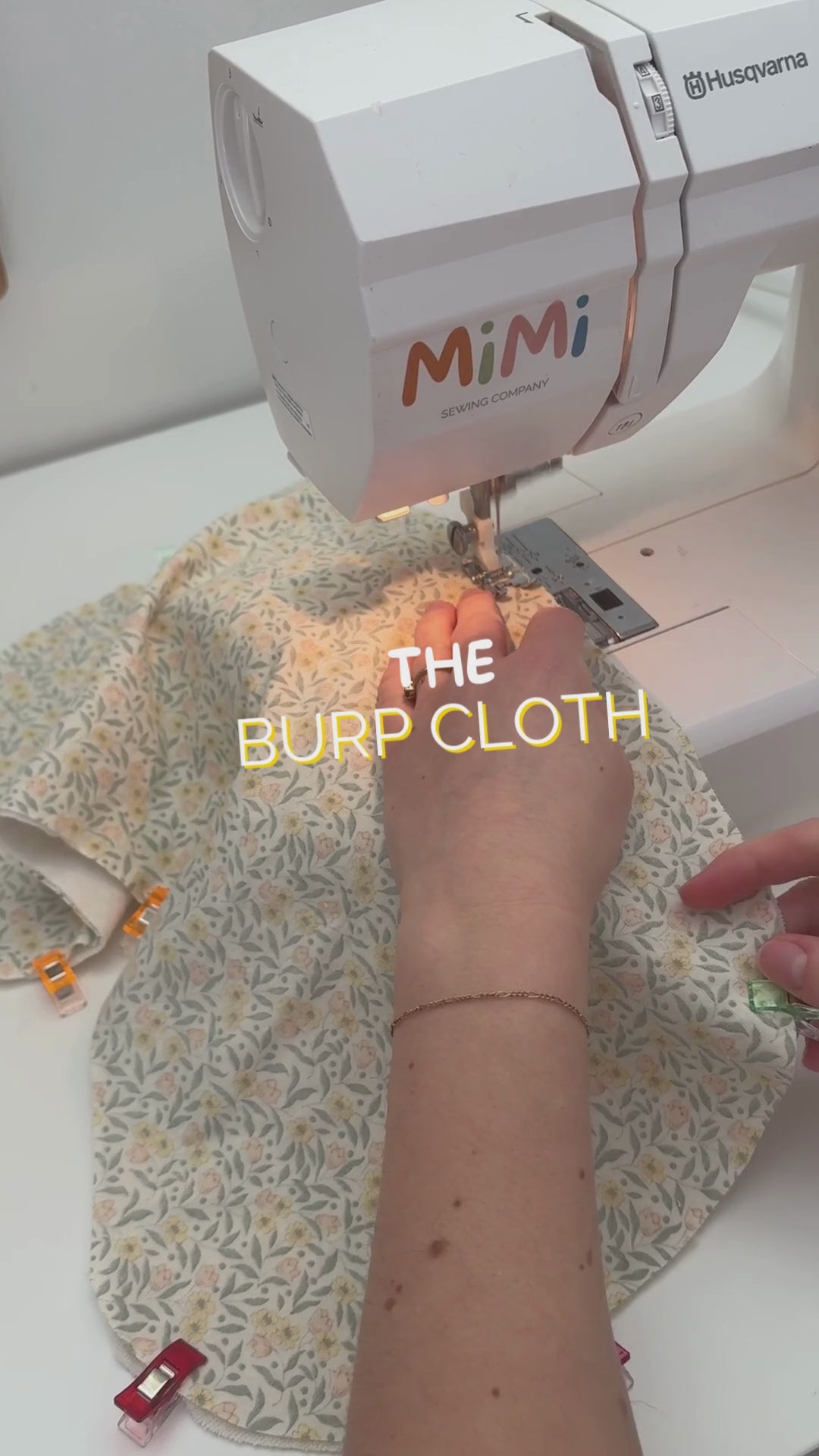 Video showing a girl sewing a burp cloth. Text on screen reads: “Sewing a burp cloth.”